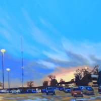 bluish sky over golden parking lot lit by last rays of sun